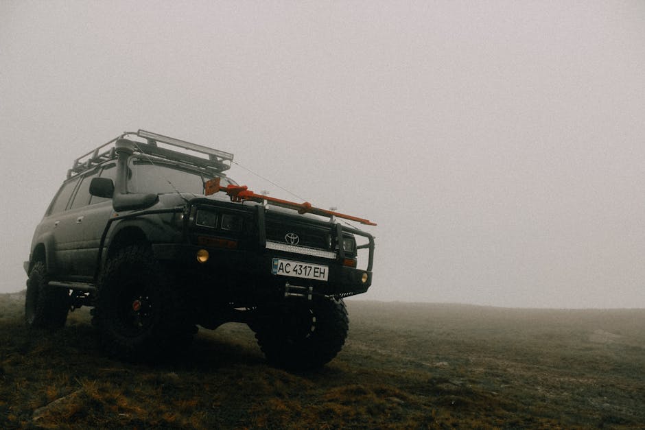 A Toyota SUV parked on a foggy offroad terrain, ready for adventure with a rugged stance.